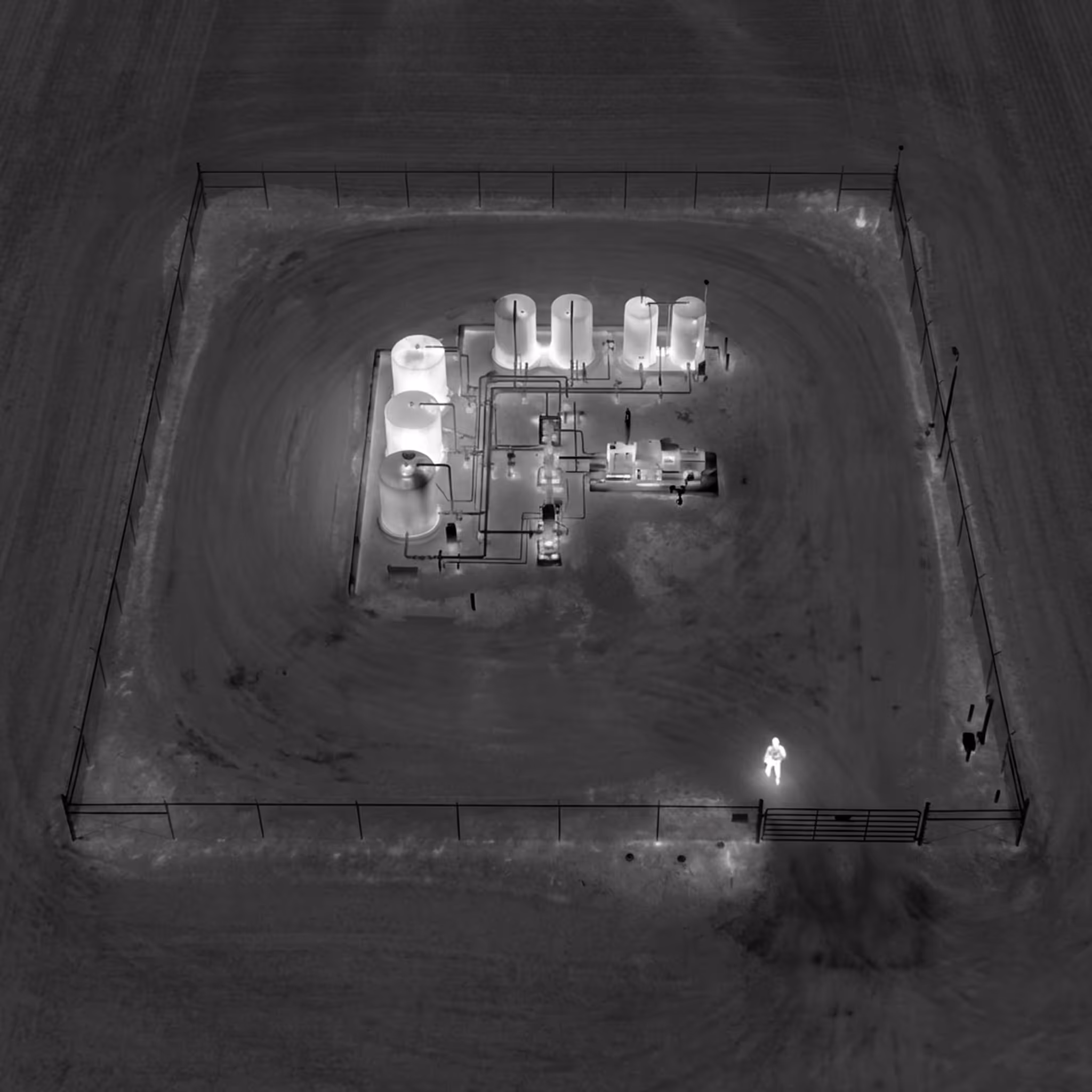 Perimeter patrol drone surveying a remote wellpad at night