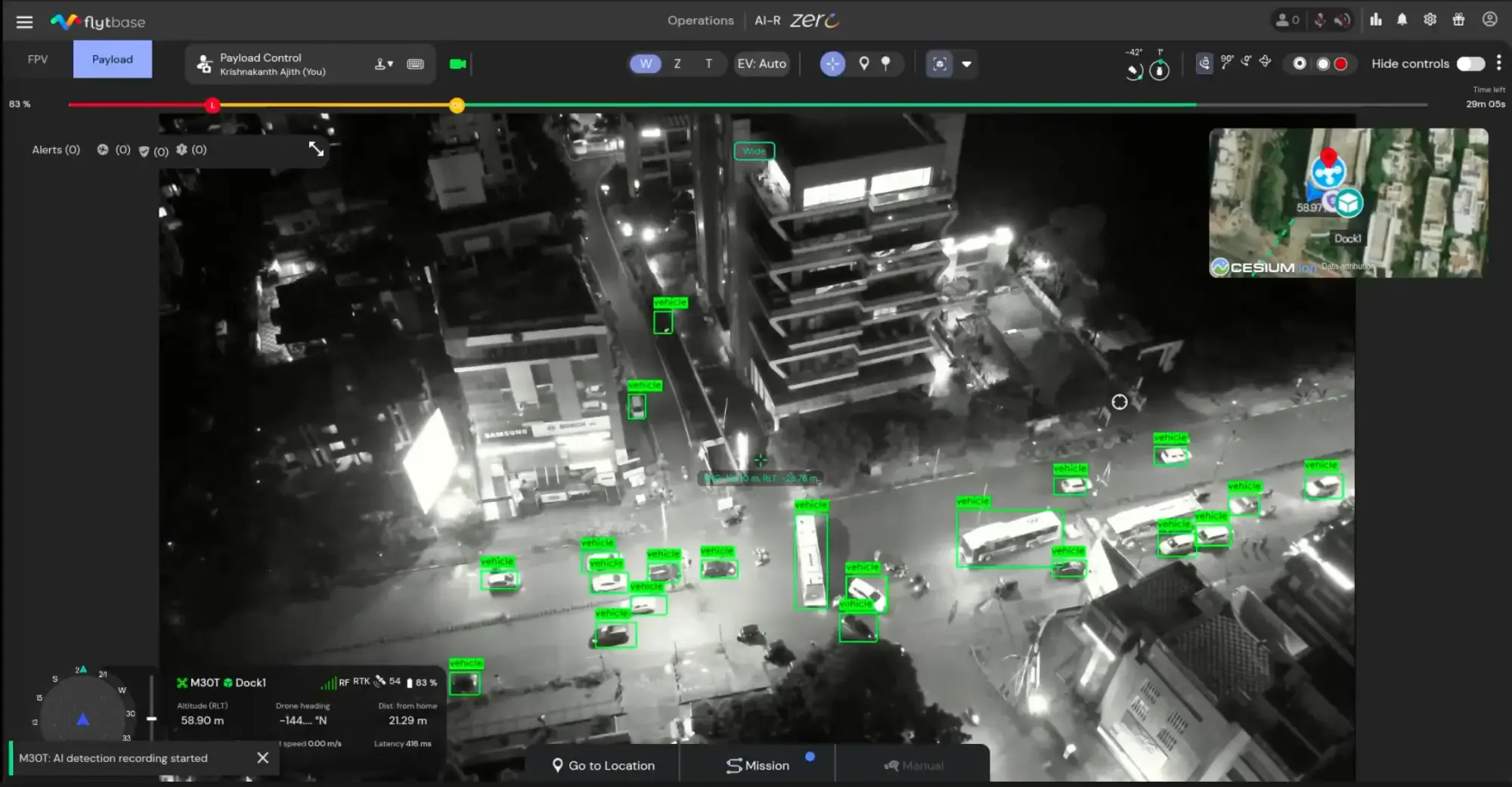 Vista nocturna térmica con dron de una intersección urbana con vehículos detectados y resaltados.