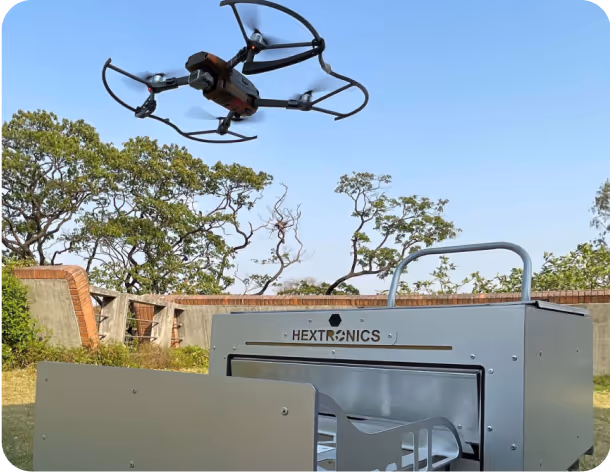 A drone flying above a metal container during an inspection demo.