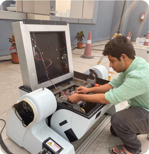 Engineer repairing a robotic device in the FlytBase lab.