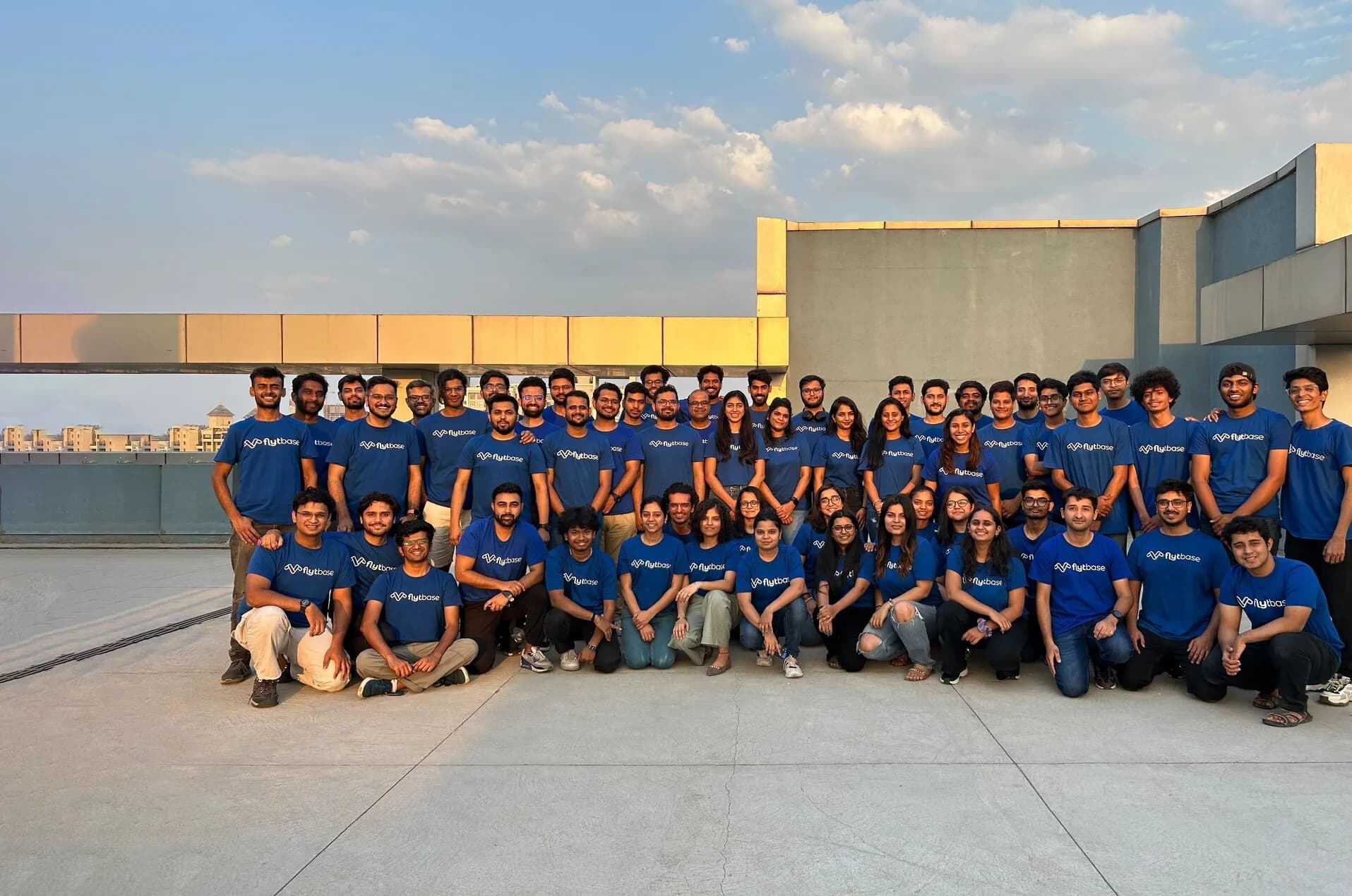 Group photo of the FlytBase team on a rooftop at sunset.
