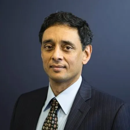 Portrait of Vasu Guruswamy in a dark suit.