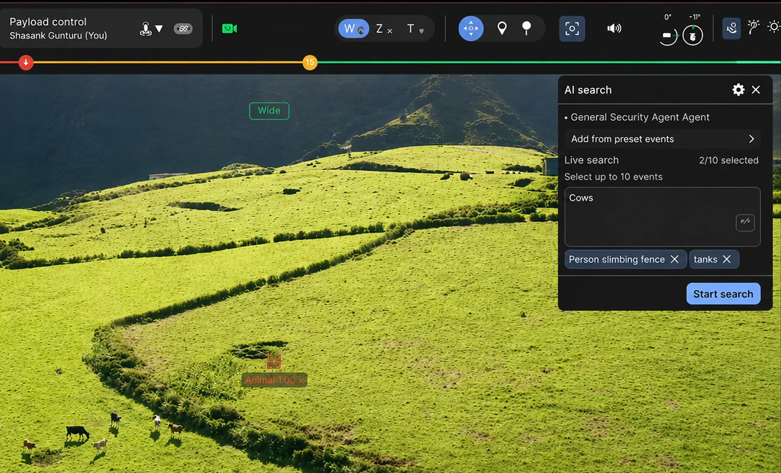 AI Search panel inside the operator console: the General Security Agent is selected, the chips "Person climbing fence" and "tanks" are already being watched, and the operator types "Cows" into the live-search field while a drone view of a hillside paddock plays beneath, with people and vehicles tagged in real time.